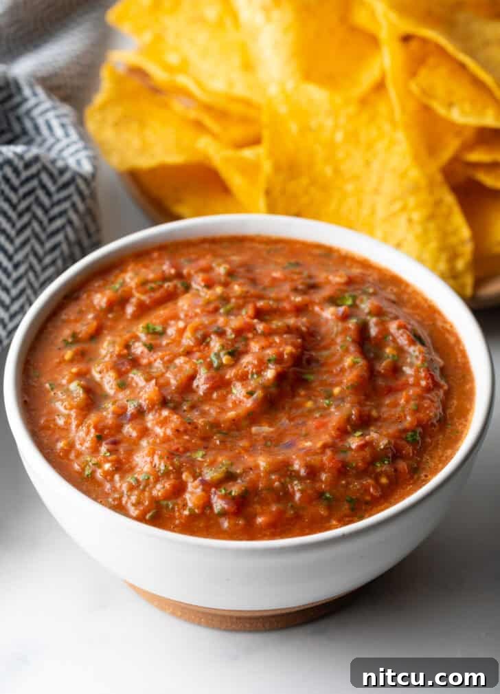 White bowl of red roasted tomato salsa.