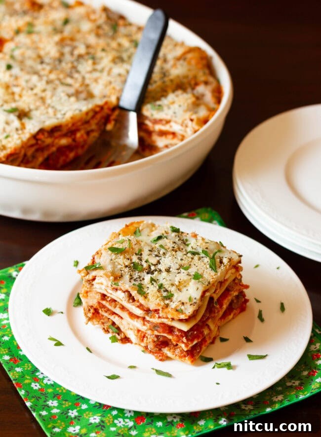 Sausage Lasagna Recipe with cream cheese and Italian sausage cut on plate - ready to serve! A delicious homemade meal.