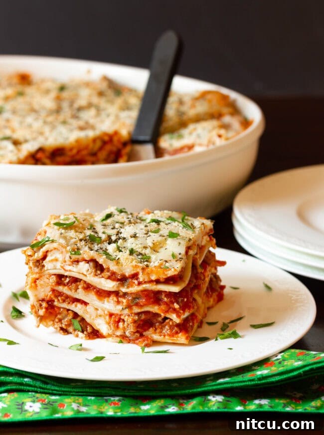 A generous slice of easy lasagna recipe with cream cheese, perfectly cut and served on a plate, showcasing its creamy layers.