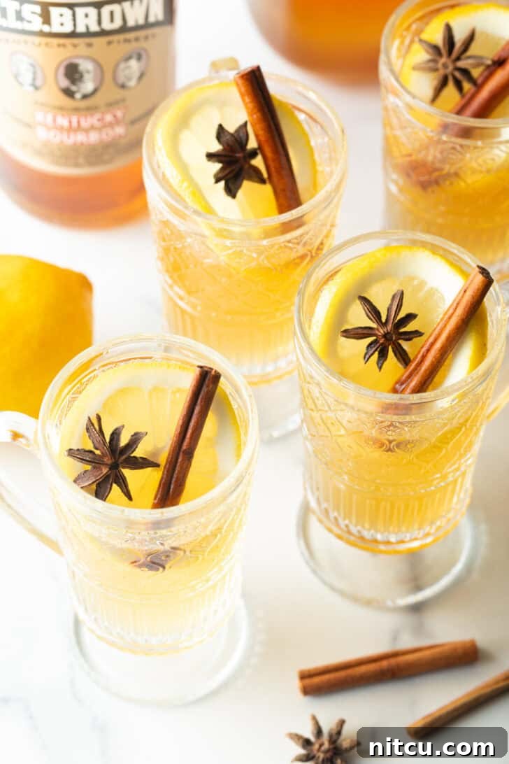3 glasses with yellow tea, garnished with a whole star anise and stick of cinnamon.