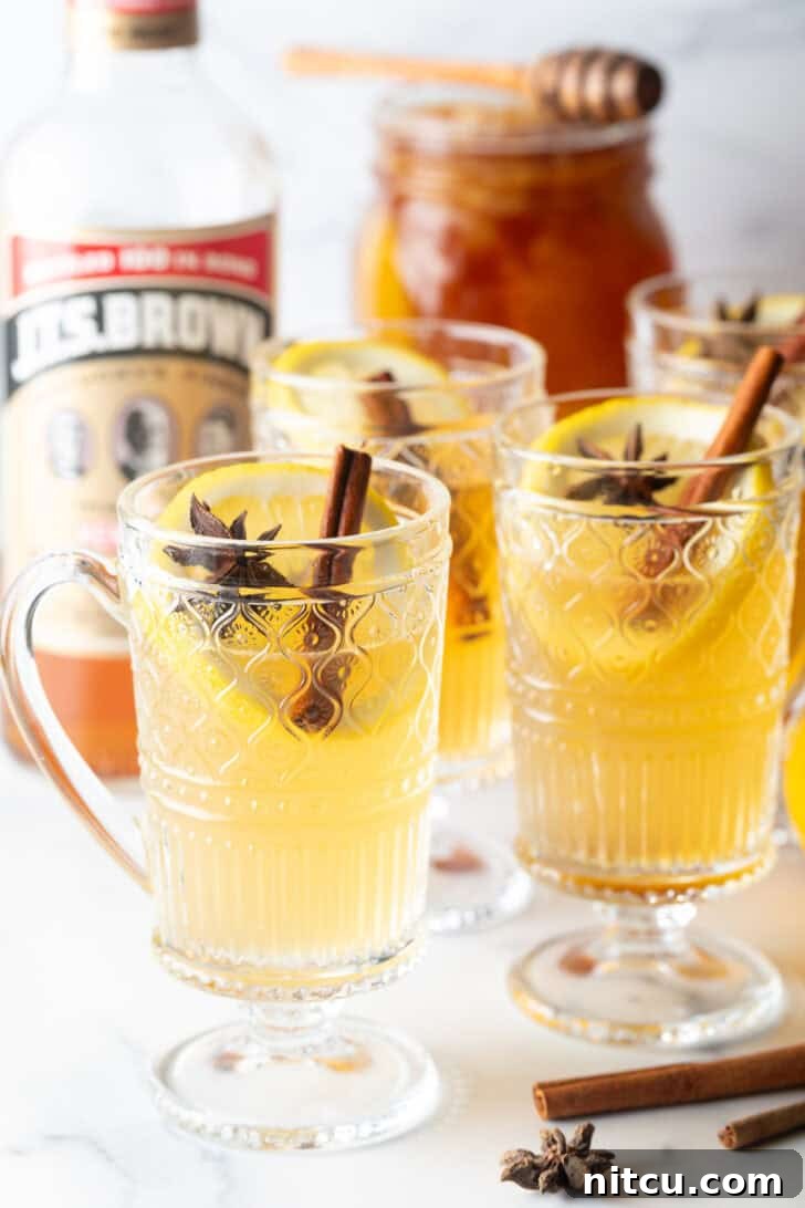 3 glasses with yellow tea, garnished with a whole star anise and stick of cinnamon.