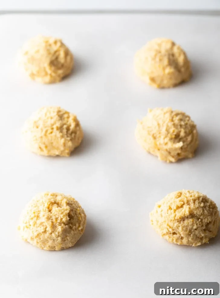 6 balls of cookie dough on a baking sheet.