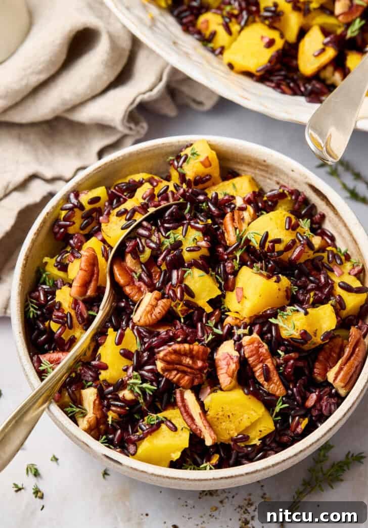 Forbidden Rice Recipe in a small bowl with a spoon, showing pecans and squash.