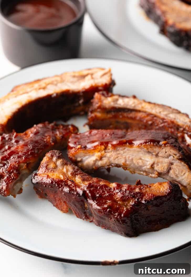 Five air-fried baby back ribs arranged artfully on a white plate, ready to be served.