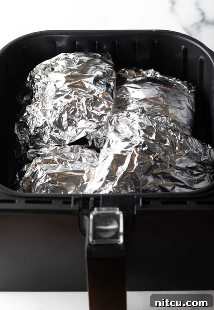 Ribs wrapped in foil cooking in the air fryer.