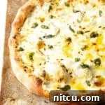 Baked whole white pizza on a baking sheet.