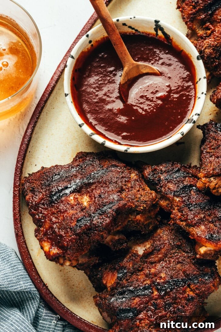 Close-up of baby back ribs with coffee BBQ sauce on a platter, ready to serve
