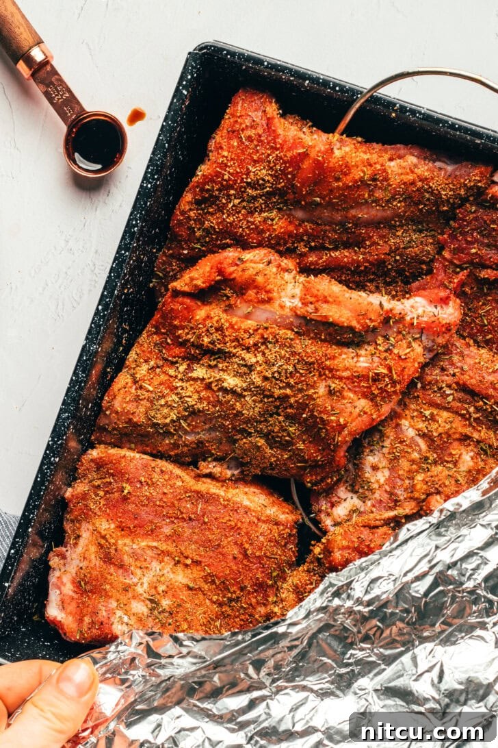 Ribs wrapped in foil baking in the oven for tenderness