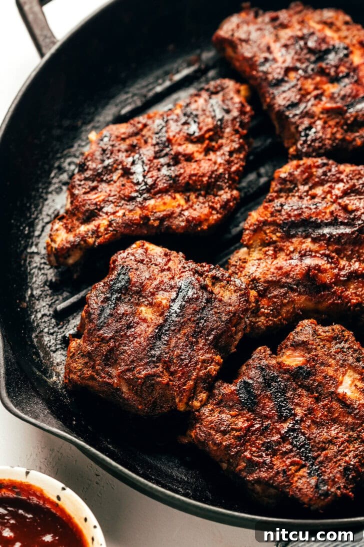 Grilled baby back ribs piled high, glistening with barbecue sauce