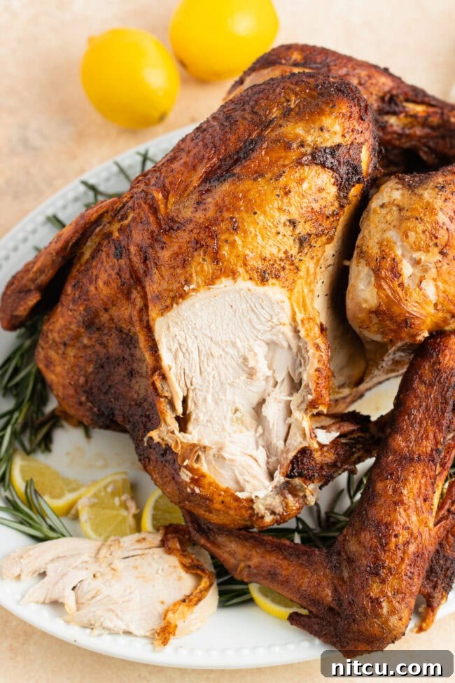 Turkey on a serving platter with a piece sliced off of the breast.