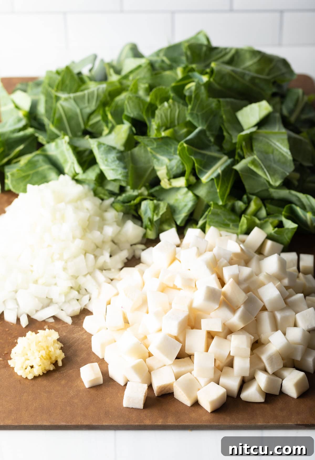 A vibrant display of fresh ingredients for Southern collard greens, including crisp greens, aromatic onions, garlic, and rich bacon.