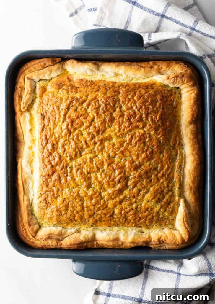 A top-down view of the square baking dish filled with the easy egg bake breakfast casserole, golden and ready to be served.