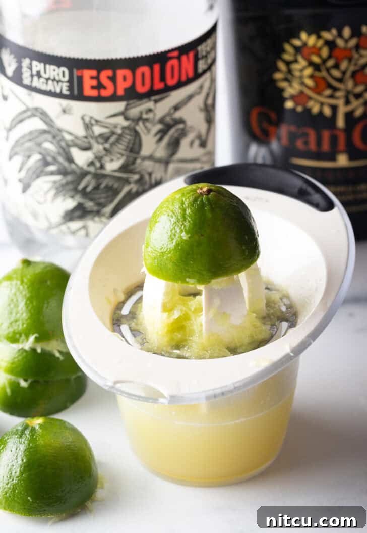 Juicing a lime over a measuring glass.