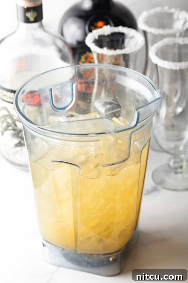 Blender jar with citrus juice and alcohol.