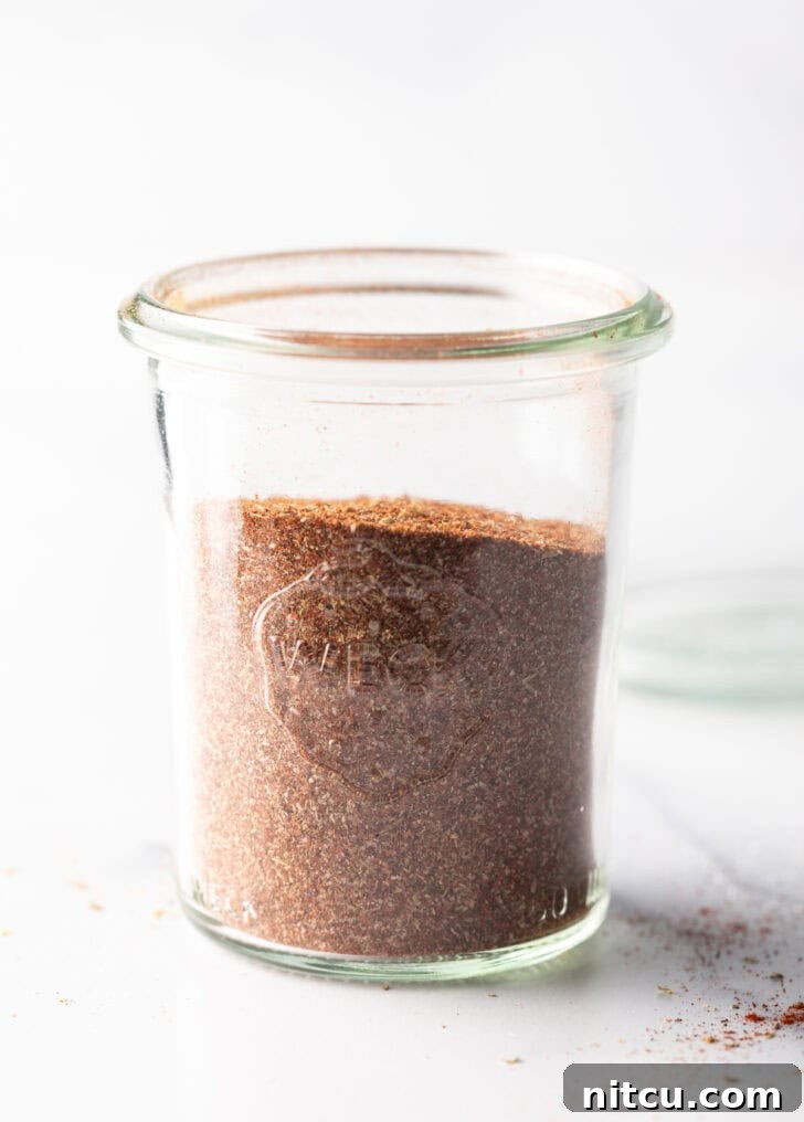 A tall glass jar showcasing the perfectly blended, uniform chicken taco seasoning, ready for culinary use.