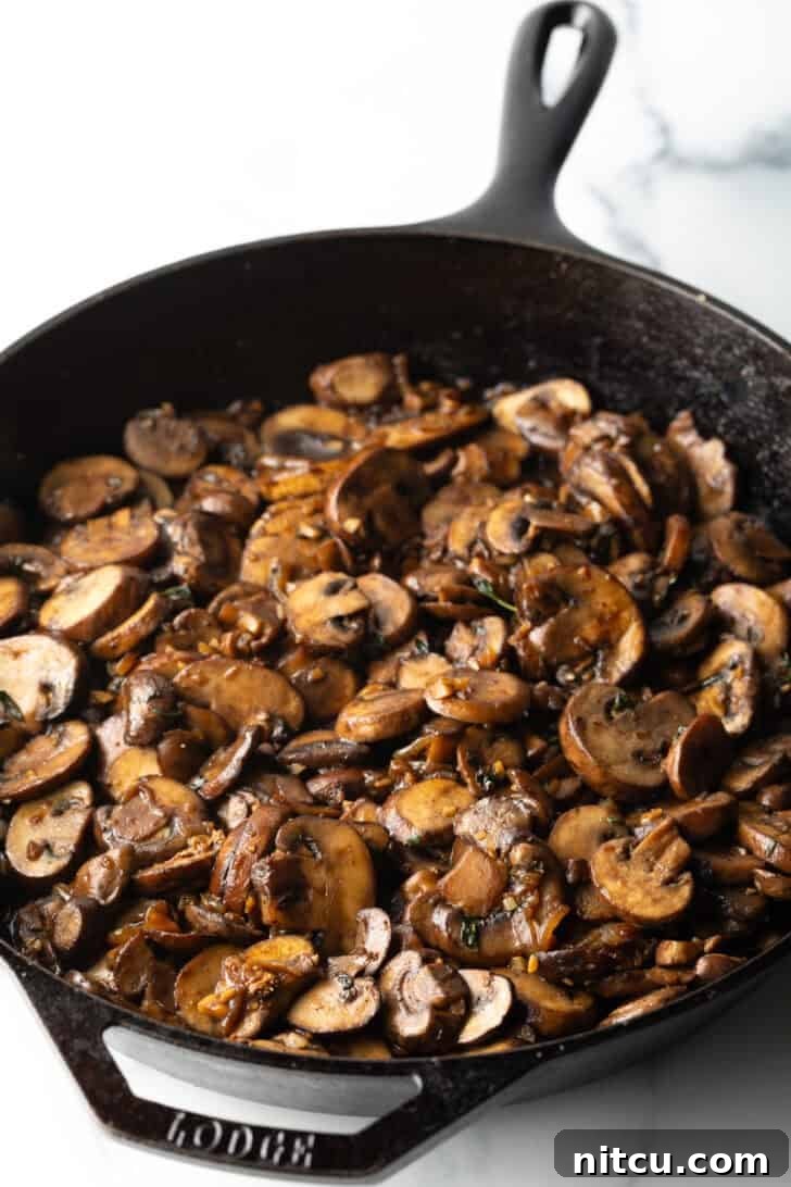 Perfectly browned and softened cooked mushrooms in a cast iron skillet, ready for sauce.