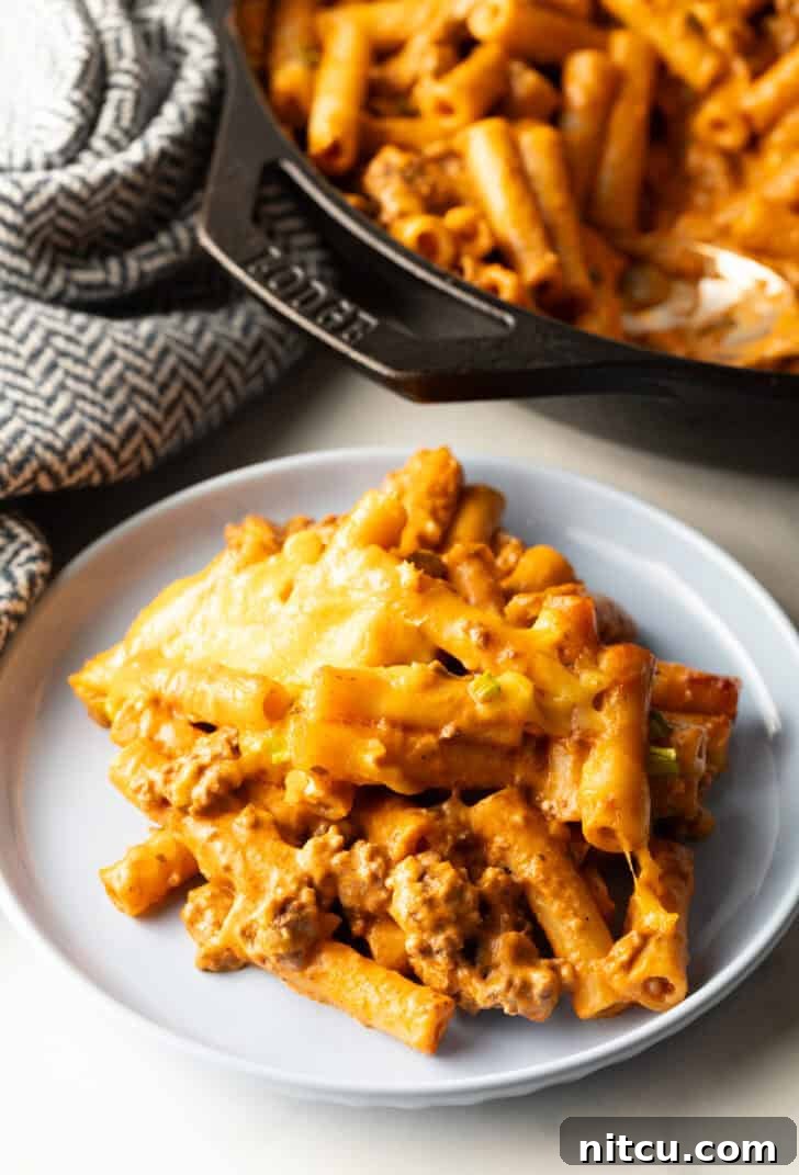 Gray plate with serving of cheeseburger casserole. A close-up showing the melted cheese, noodles, and ground beef.
