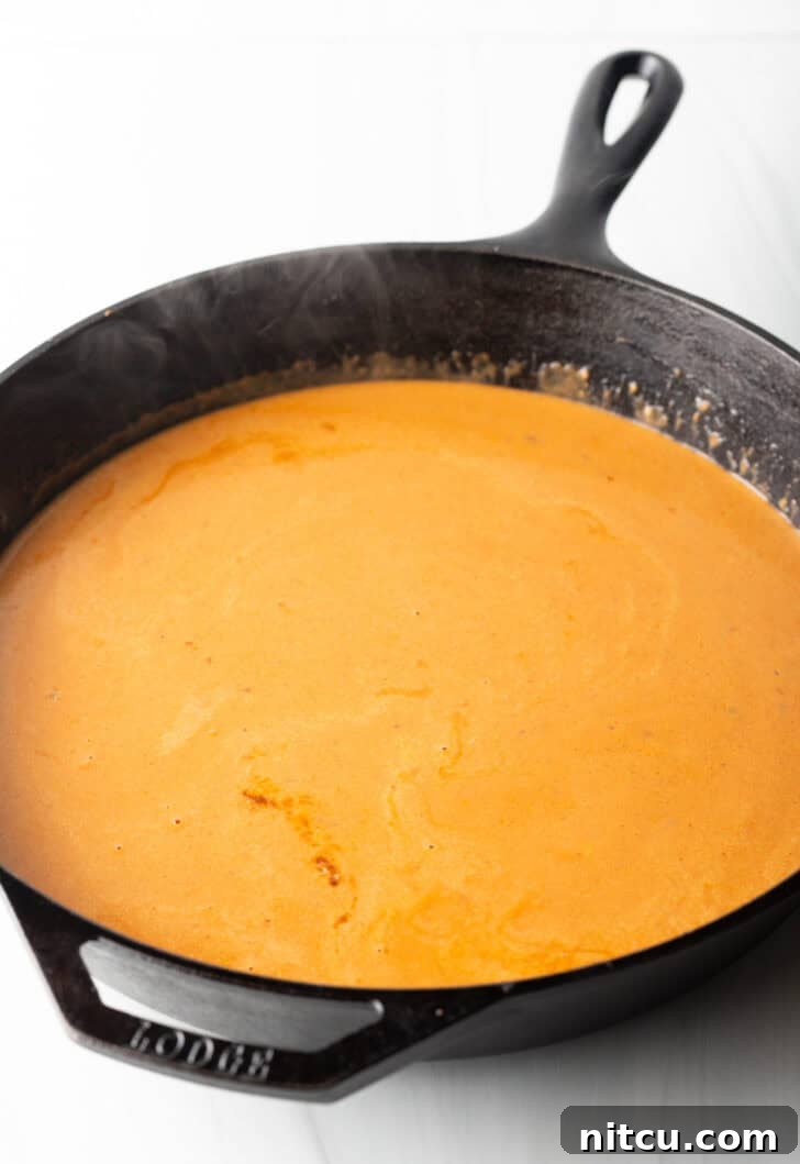 A rich, creamy tomato sauce simmering in a cast iron skillet.