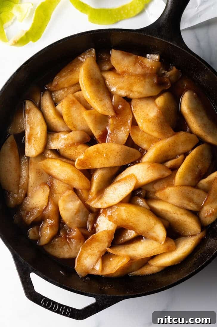Close-up of a cast iron skillet filled with freshly cooked spiced fried apples.