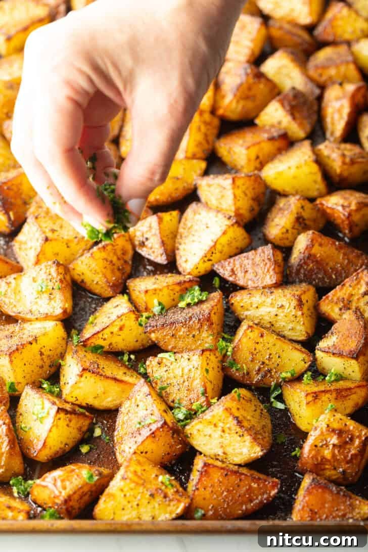 Roasted golden potatoes on a baking sheet.