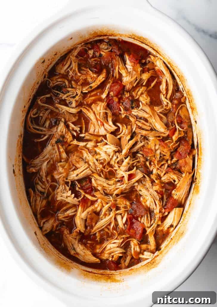 Top down view shredded Mexican chicken in a crockpot.