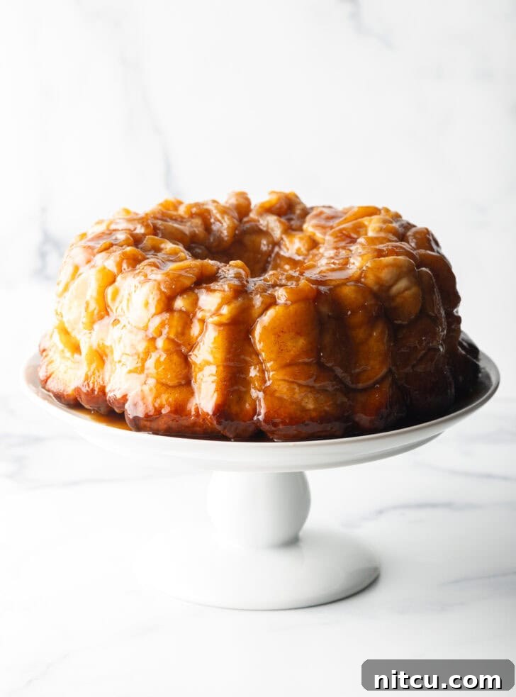 Monkey bread baked in a bundt pan, plated on a white cake stand.