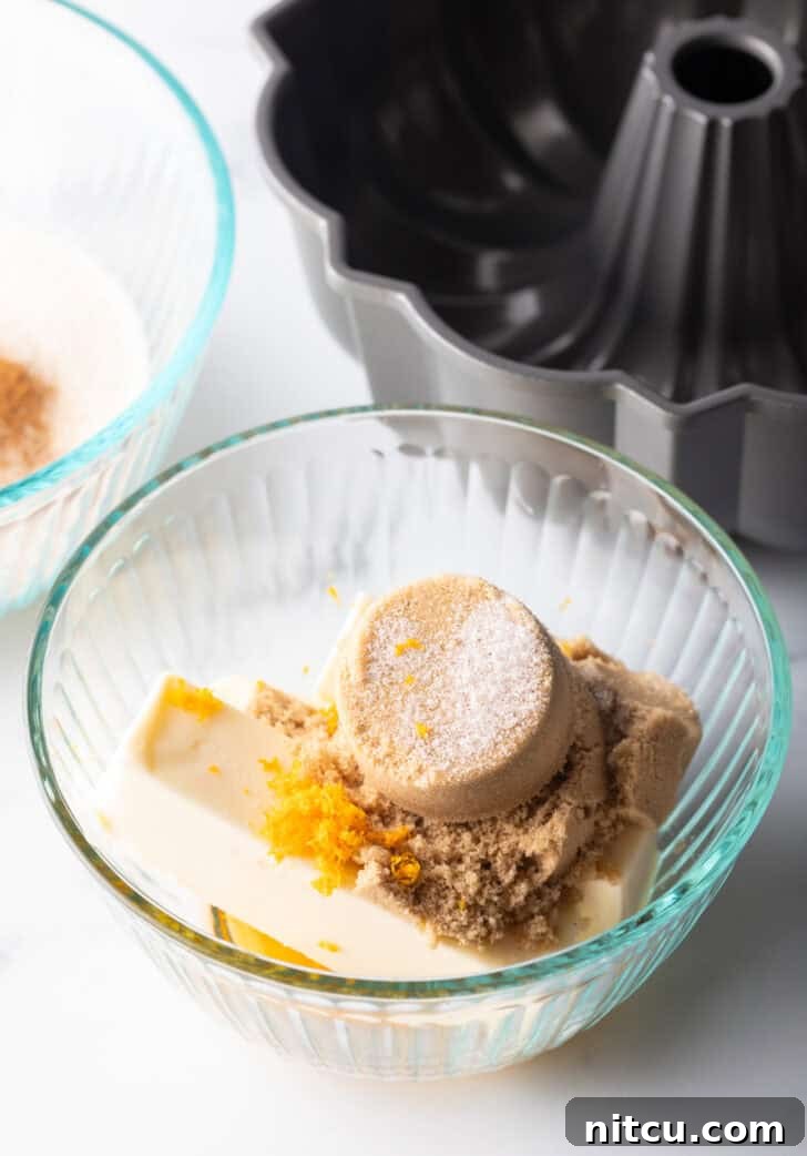 Glass bowl with brown sugar, orange zest, butter, and pumpkin pie spice.