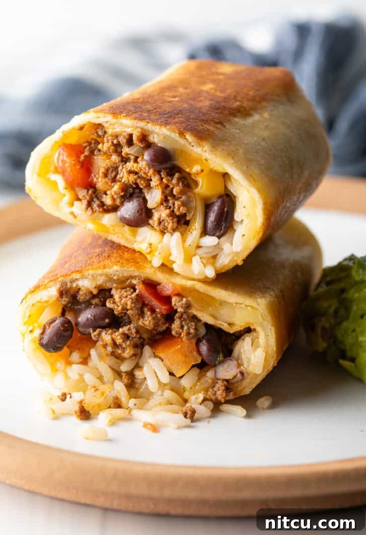 Two halves of a beef and cheese burrito stacked on top of each other, ready to be picked up and savored.