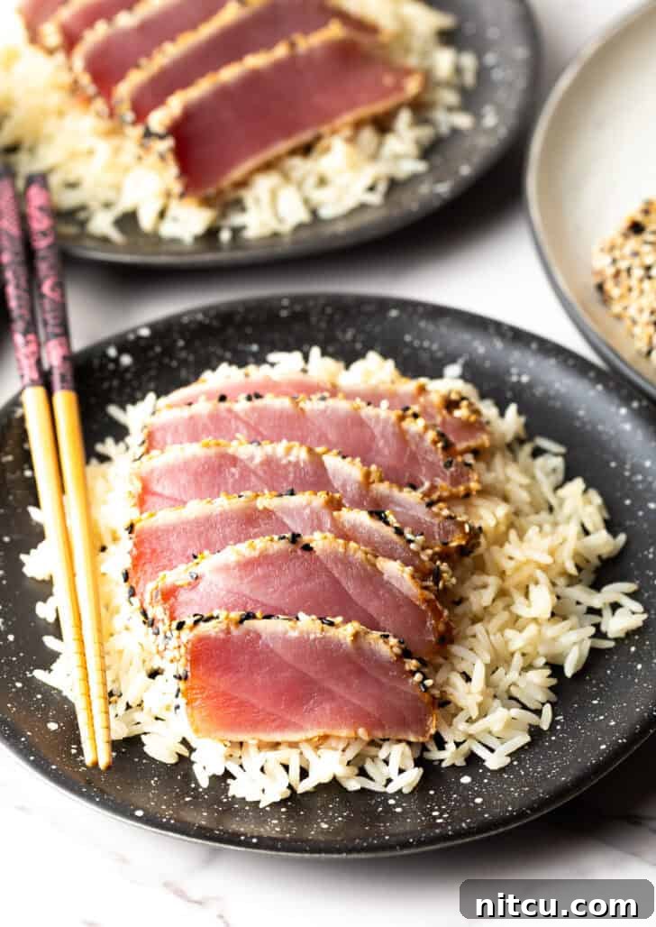 Top-down view of six slices of beautifully seared ahi tuna on a bed of white rice, ready to be enjoyed.