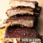 St. Louis style ribs stacked on top of each other on cutting board.
