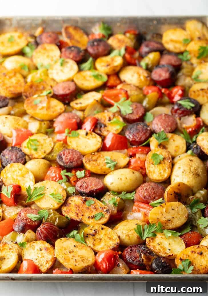 Side view of a serving of sheet pan sausage and veggies, highlighting the roasted textures.