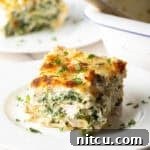 A beautifully plated square of chicken Alfredo lasagna, showcasing its creamy layers and perfectly melted cheese.