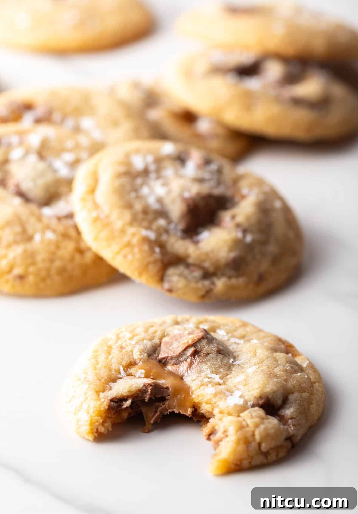 Close up shot of a Milky Way cookie with a bite taken out, showing the gooey interior.