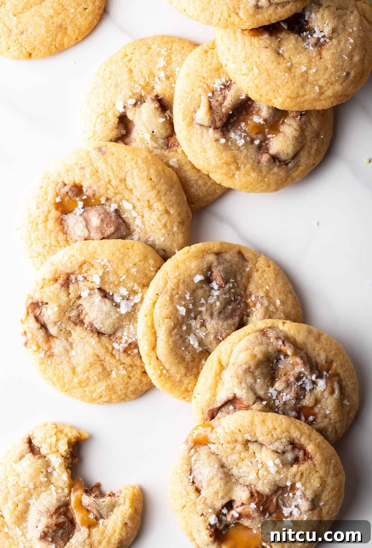 A batch of freshly baked Milky Way cookies stacked horizontally in an appealing swirl pattern on a white surface.
