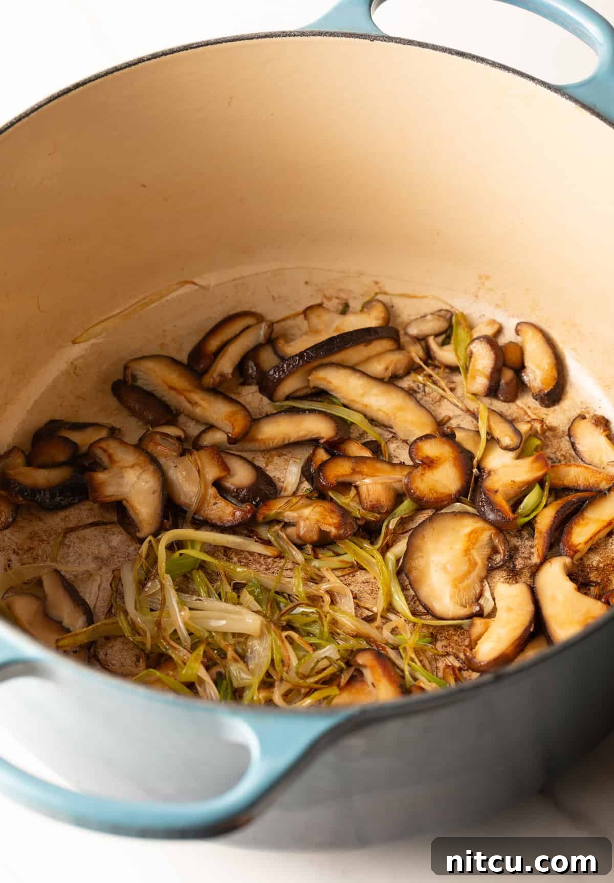 Pot of shiitake mushrooms and green onions after being stir-fried.