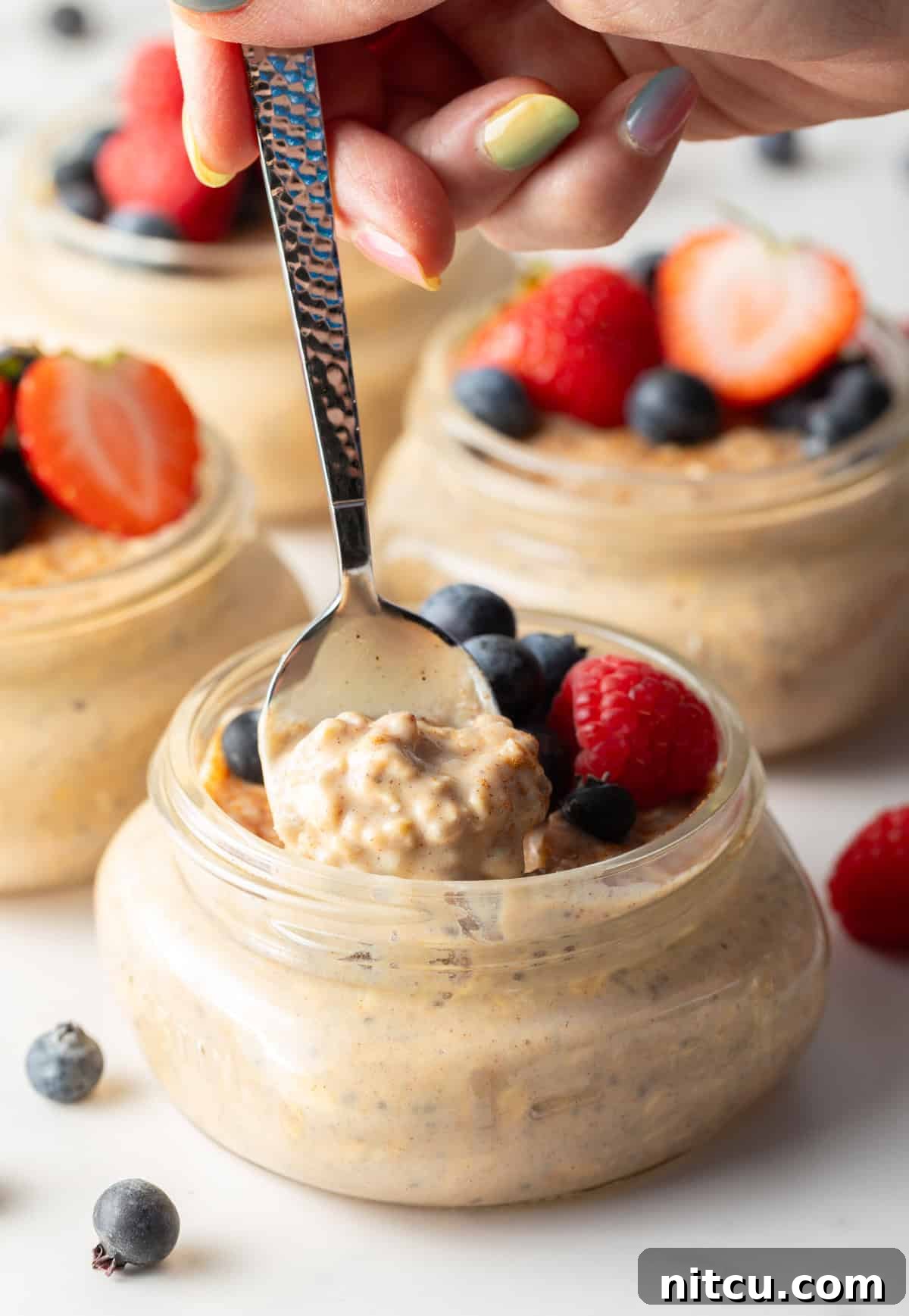 A spoon taking a bite out of a jar of high protein oatmeal.