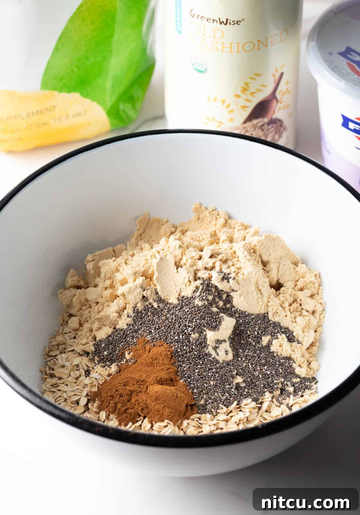 Dry ingredients for high protein overnight oats recipe in a white bowl.