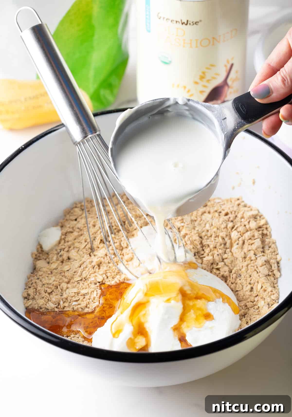 Milk being poured over the ingredients for high protein overnight oats recipe.