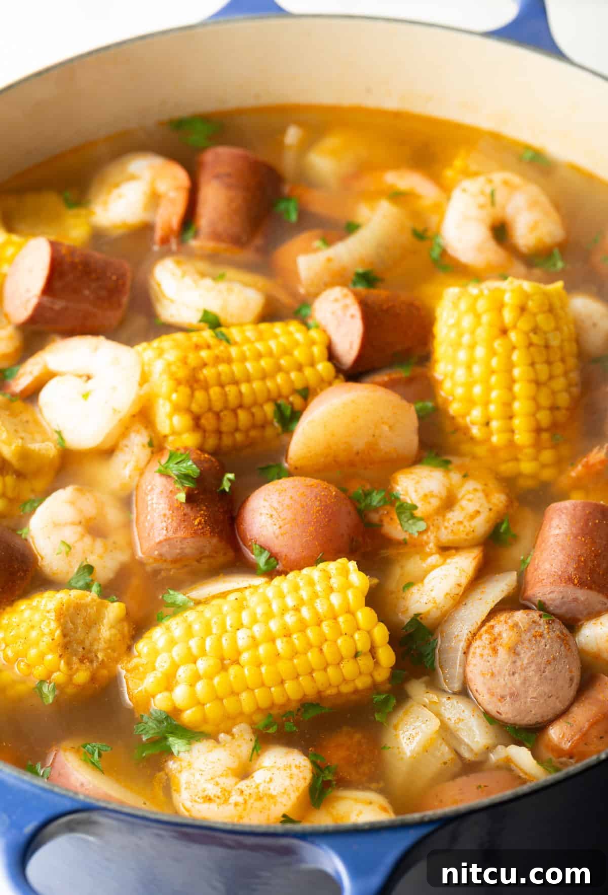 The fully cooked Low Country Boil, a harmonious mix of perfectly cooked shrimp, tender potatoes, sweet corn, and savory sausage, beautifully seasoned with Old Bay, ready to be served.