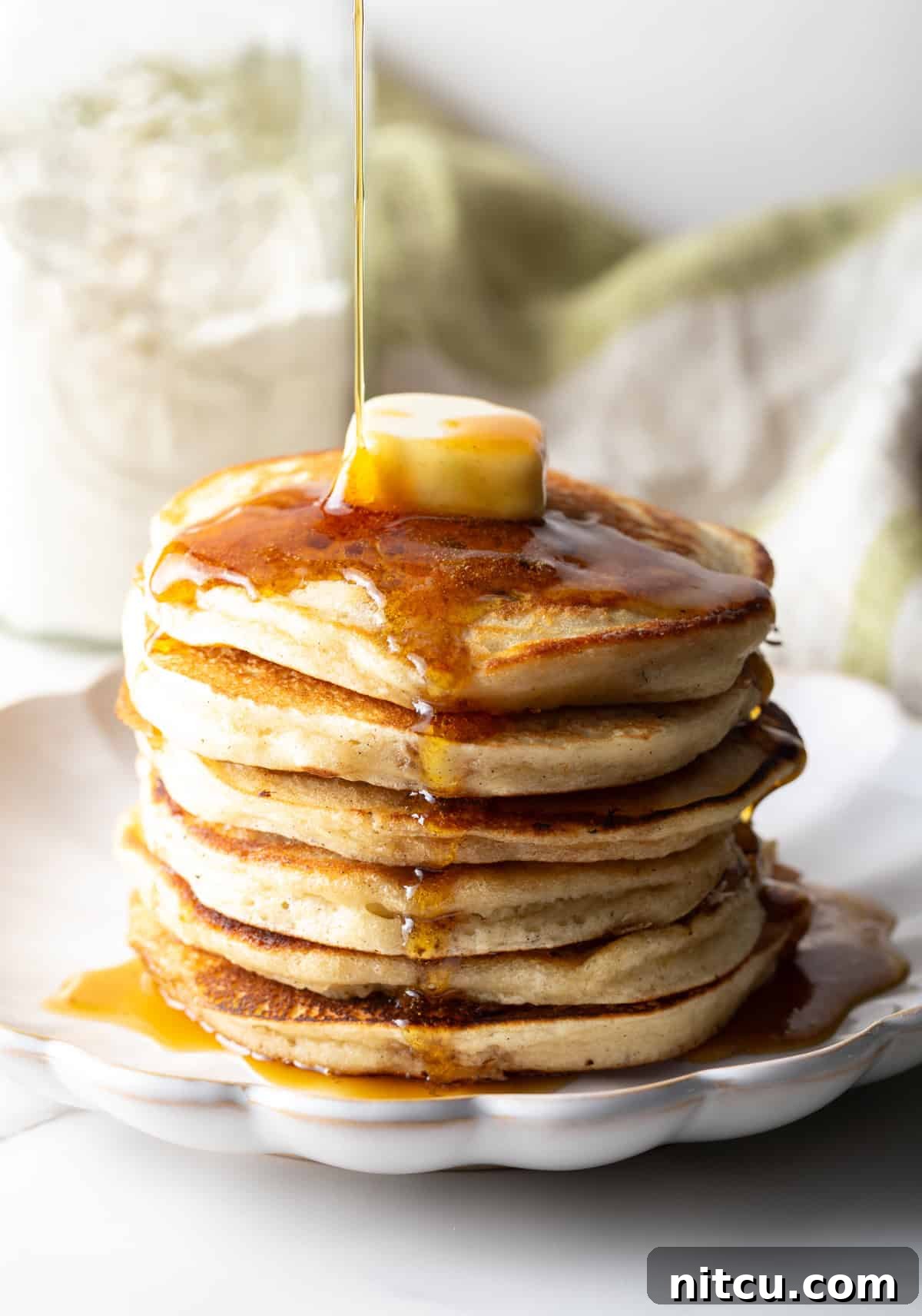 A fluffy stack of pancakes with butter and syrup, made with a homemade pancake mix recipe.