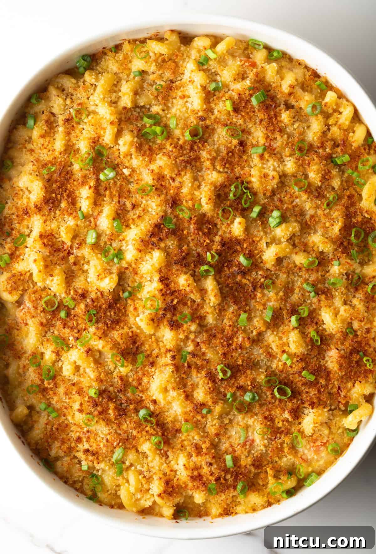 Overhead shot of Cajun mac and cheese with crispy baked topping in a white baking dish.