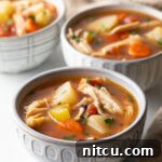 3 small white bowls of chicken stew with potatoes, carrots, and celery in a tomato broth.