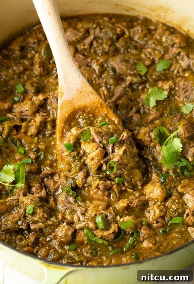 A vibrant assortment of fresh vegetables and spices, including chopped onions and garlic, prepared for making green chili.