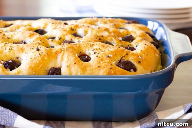 Blue baking dish with roasted garlic and olive focaccia bread.