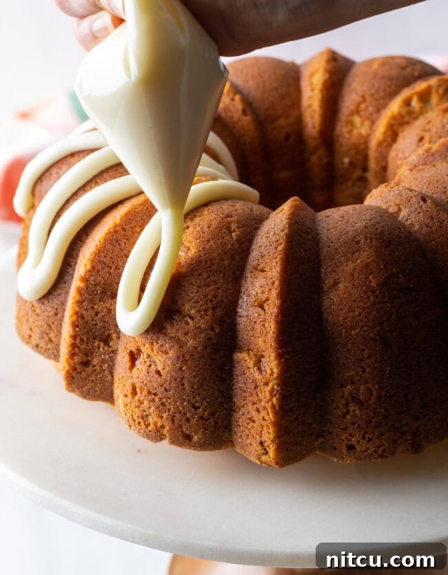 Detailed close-up of the peach bundt cake, showcasing the smooth, sweet glaze dripping down its sides.