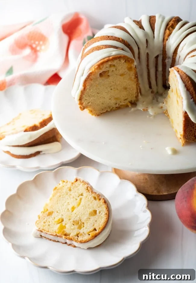 A freshly cut slice of Peaches and Cream Bundt Cake resting on a plate, showing its moist interior.