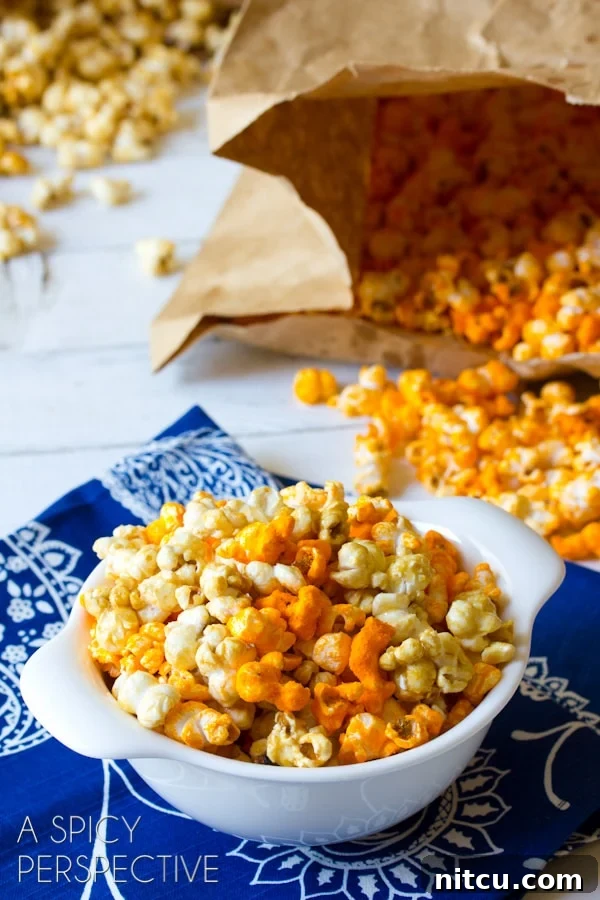White bowl filled with a mixture of caramel and cheddar popcorn.