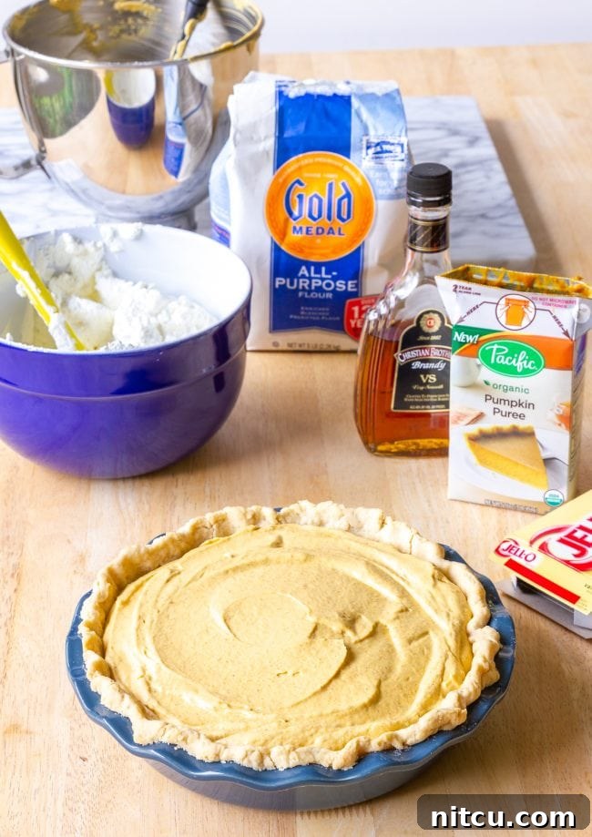 Individual ingredients like cream cheese, pumpkin puree, and spices arranged for pumpkin cream pie