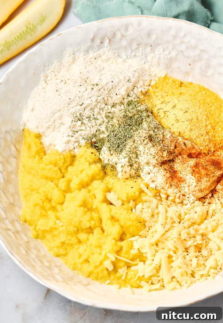 Bowl filled with mixed Southern Squash Casserole ingredients, showing a creamy texture with shredded cheese