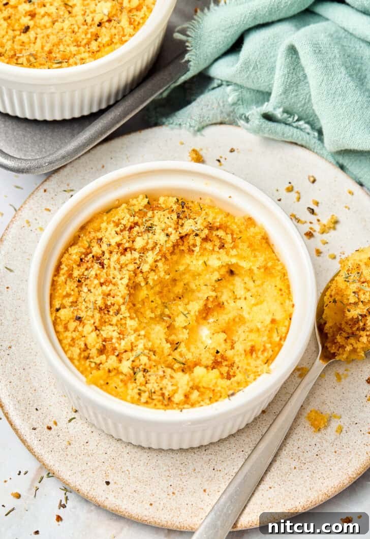Close-up of squash casserole with a spoonful removed, revealing the soft, creamy interior and crispy top
